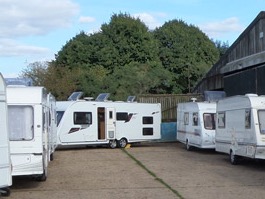 Caravans parked in the yard beside the barn